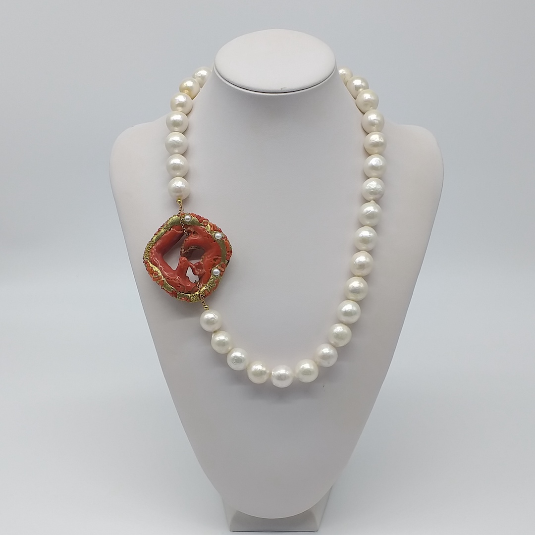 48) SING. 39-149 Collana corta con un filo di Perle coltivate barocche bianche. Grande creola di Corallo naturale del Mediterraneo con pregiata lavorazione dorata, posta lateralmente. Chiusura in Argento 925 dorato nichel free.